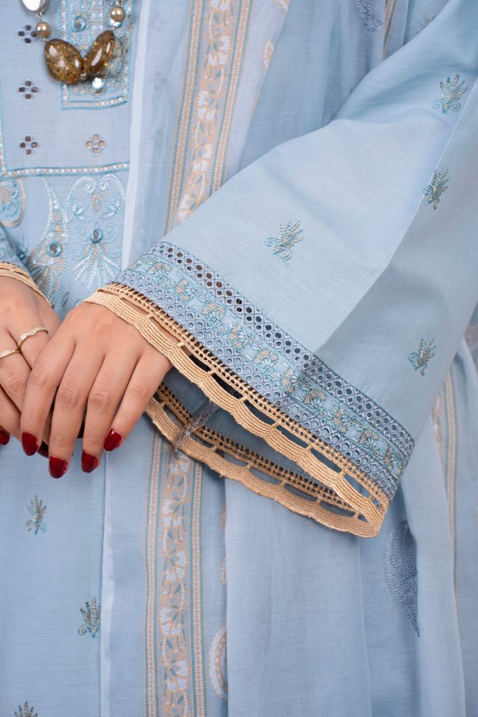 Close-up of a woman's hands in an elegant embroidered blue traditional dress.